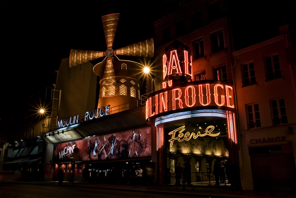 A night time photo of the neon lights of the Moulin Rouge night club with its famous faux windmill.
