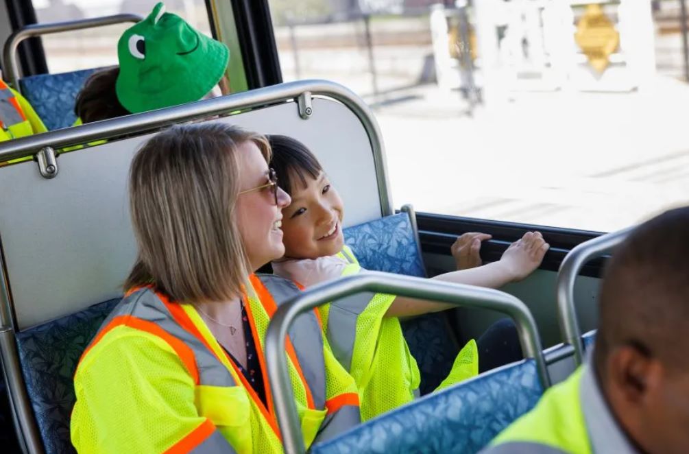 Allison and her elementary age daughter are in bright yellow safety vests aboard a Metro bus.